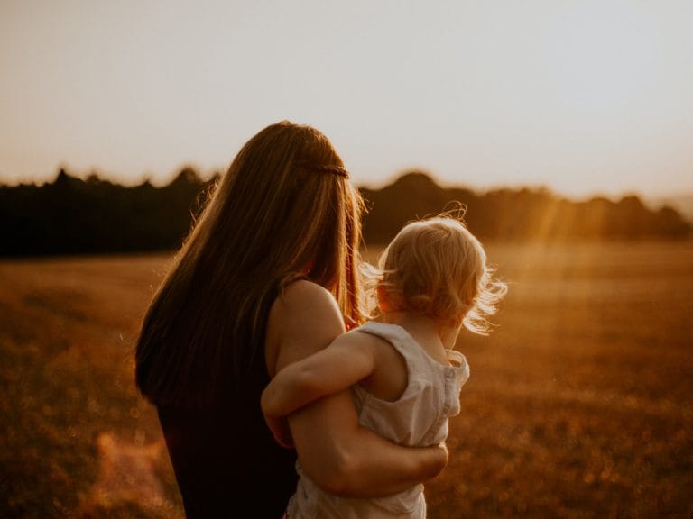 uważna mama z niemowlakiem na ręce