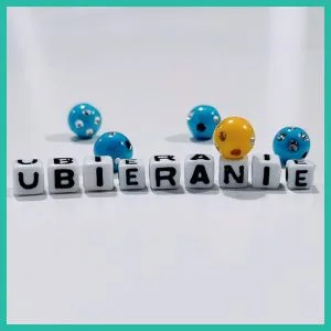 napis "ubieranie" i koraliki kolorowe